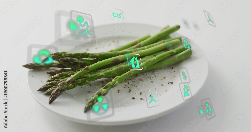 Fototapeta premium Showing bundle green asparagus spears diagonal on white plate in studio with pepper and AR icons