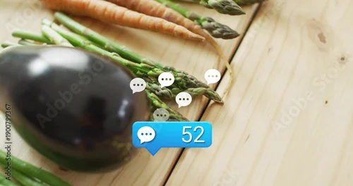 Fototapeta Displaying eggplant asparagus carrots on light wood table, with white speech icons and blue chat 52
