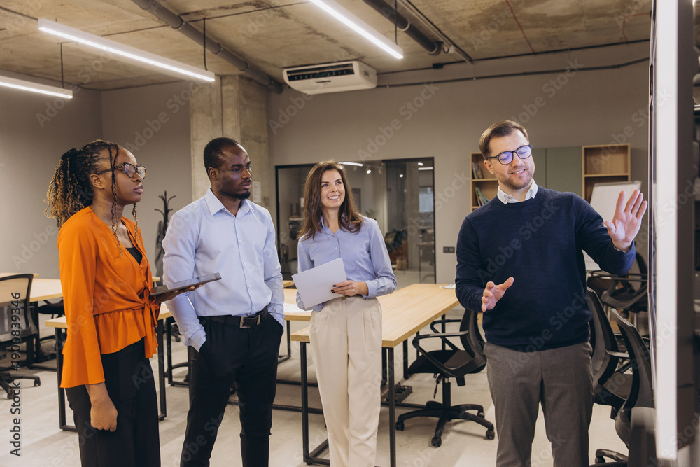 Fototapeta premium Diverse professionals collaborating during business meeting, strategizing in modern open plan office with collaborative workspace layout