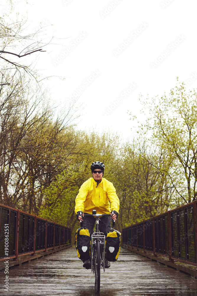 Obraz premium Bridge, exercise and man on bicycle in winter for fitness, active hobby and training outdoor. Sports, park and person on bike for cycling, workout and endurance for wellness, practice and health
