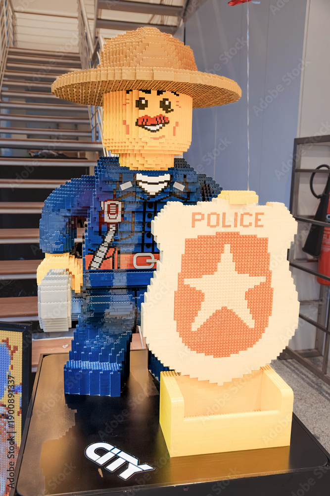 Obraz premium 1 December 2025, Doha, Qatar: Giant LEGO toy figure of a police officer made from plastic construction bricks, standing with a yellow badge