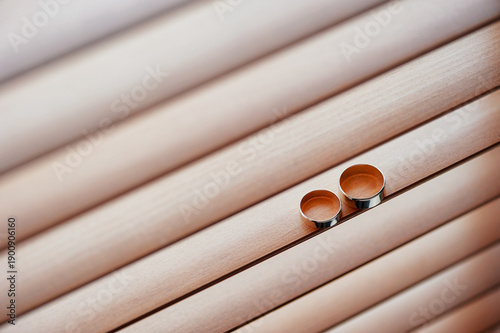 Fotografie A close-up view of two wedding rings placed against a wooden background, symbolizing marriage, love, and a lifelong commitment, capturing the essence of a wedding or romantic union