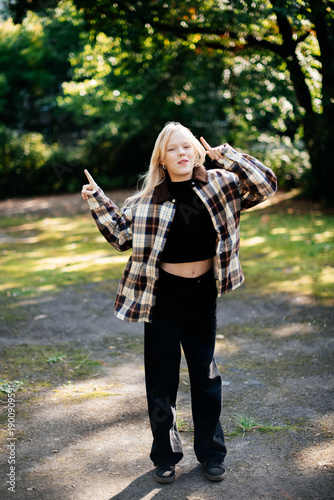 Happy Teenage Girl Dancing Playfully Outdoors in Casual Street Style