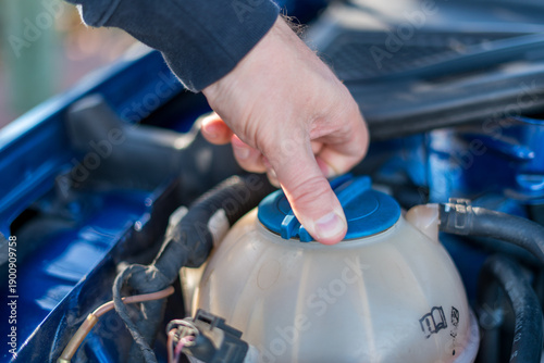 Obraz na plátně Hand opening coolant reservoir cap in car engine close up
