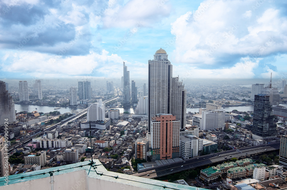 Obraz premium Urban City Skyline View with High-Rise Buildings and Blue Sky