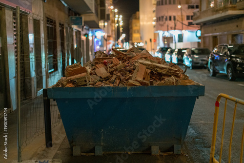 Foto Construction waste dumpster on city street at night