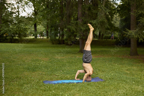 Canvastavla Individual executing handstand on blue mat in park environment