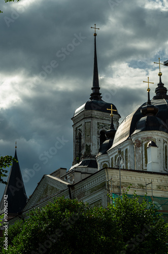 Orthodox cathedral domes and spires under dramatic storm clouds in Tartu