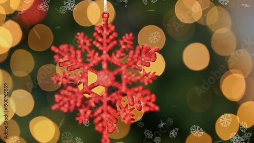 Animation of snowflakes floating over hanging snowflakes decoration against spots of light