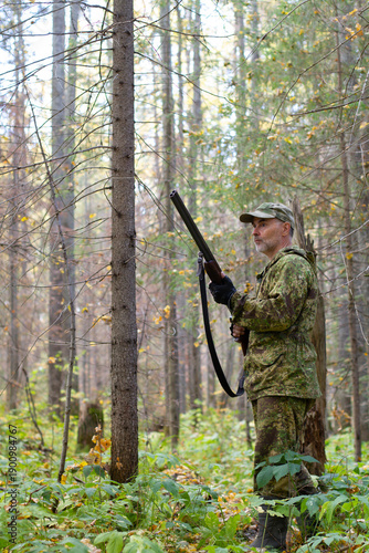 A sportsman holds a shotgun at the ready
