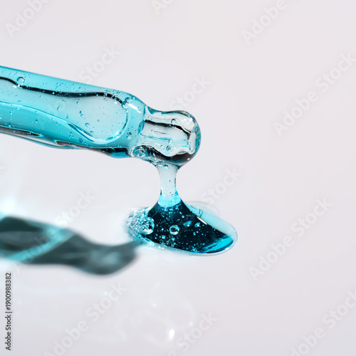 Pipette with serum, gel, oil or other cosmetic product on white background. Macro closeup