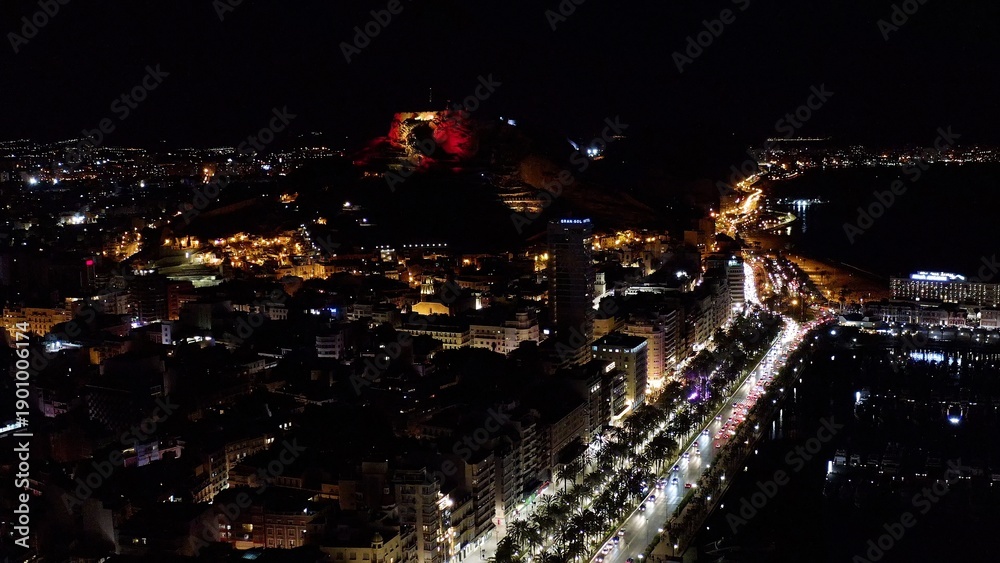 Obraz premium Nocturne aerial view of Alicante port, Postiguet Beach and the buildings next to the city center in the Mediterranean city of Alicante, Spain.