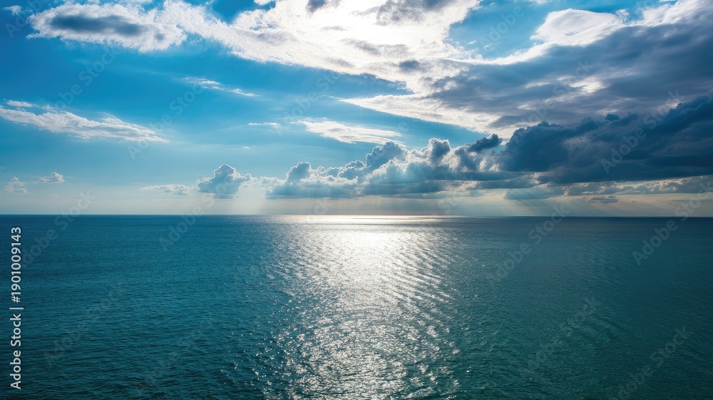 Obraz premium Serene ocean landscape with dramatic cloudy sky and sunlight reflection