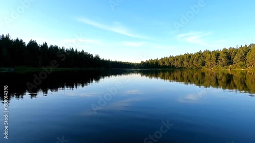 Serene Lake Surrounded by Lush Green Forest.