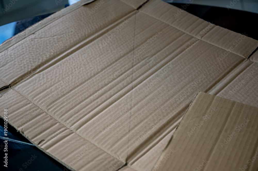 Fototapeta premium Cardboard sheet on table. DIY, hobby, and creative workspace concept. Copy space.