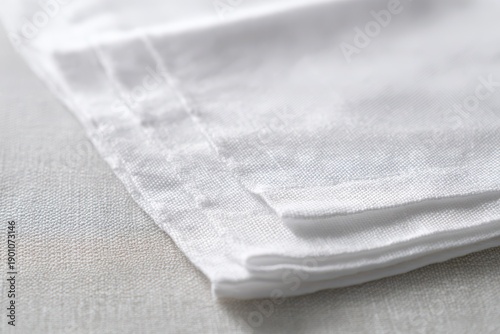 Pristine white batiste handkerchief laid flat with crisp edges and subtle folds