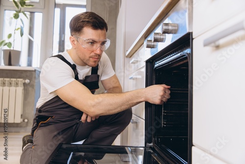Photography Plumber Repairing Oven in Kitchen