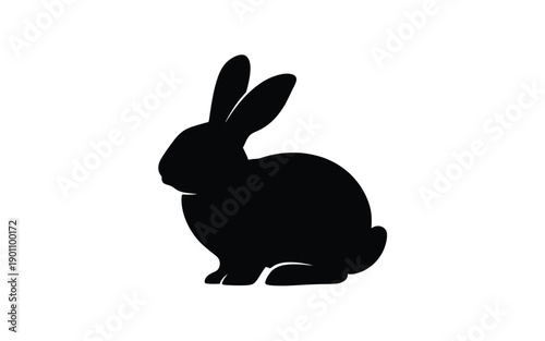 Black silhouette of a rabbit sitting in profile with ears perked up on white background