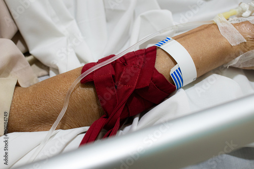 Fotografía Patient’s hand gently restrained to prevent removal of an IV line, illustrating hospital safety procedures