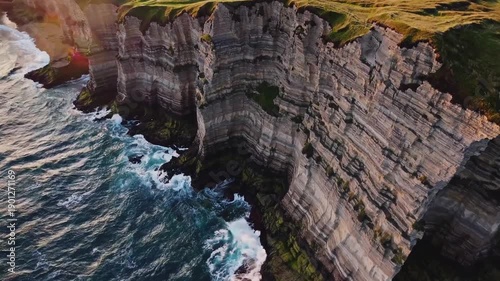 Wallpaper Mural Majestic Cliffs Embrace the Sea: A breathtaking view showcases towering cliffs meeting the sea, revealing layers of rugged rock formations. The powerful waves crash against the base.  Torontodigital.ca