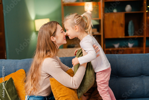 Billede på lærred Mother and daughter sharing a loving moment, bonding at home in living room