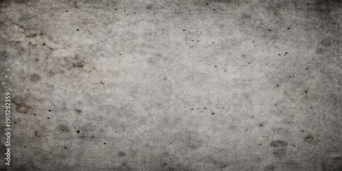 A blank antique vintage paper texture with an aged grunge pattern overlaying a rough dark grey concrete wall surface for a dirty cement material design