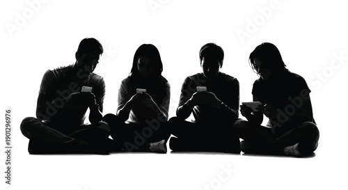 Group of four young adults sitting cross-legged engrossed in their individual mobile devices