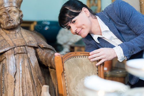 Φωτογραφία portrait of a lady inspecting antique chair