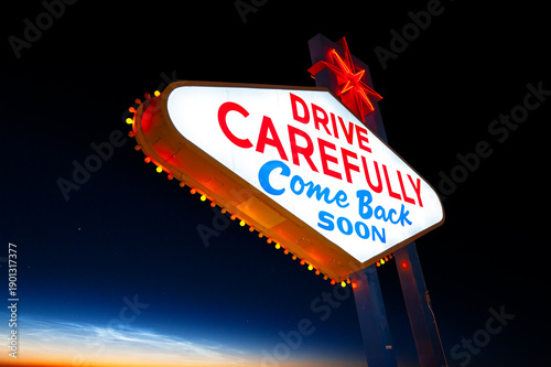 Drive Carefully Come Back Soon Sign, Welcome to Fabulous Las Vegas Sign. Logo Removed. The beautiful sunset sky in the background.