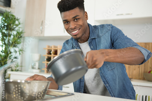 man straining food through a collander