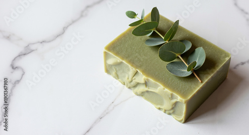 Natural green soap with eucalyptus leaves on marble background  