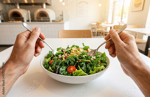 POV First-Person View of Hands Holding Spoon and Fork Over Fresh Salad Plate in Modern Pizza Restaurant