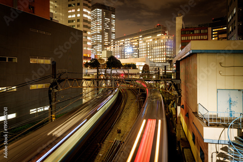Tableau sur toile Long exposure of trains moving through Tokyo city at night, Japan