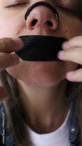 Latina woman using nasal strip and mouth tape for sleep and breathing - Biohacking and wellness. Vertical video