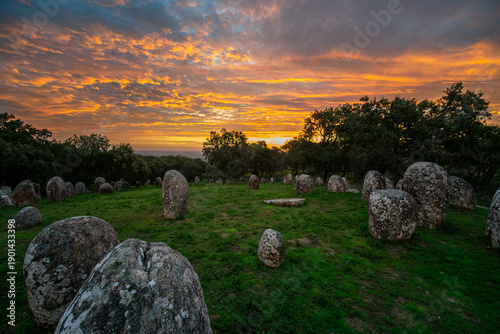 Sunrise at the Cromeleque dos Almendres near Évora, Alentejo, Portugal. An ancient Neolithic stone circle, one of the largest megalithic monuments in Europe, bathed in soft morning light.