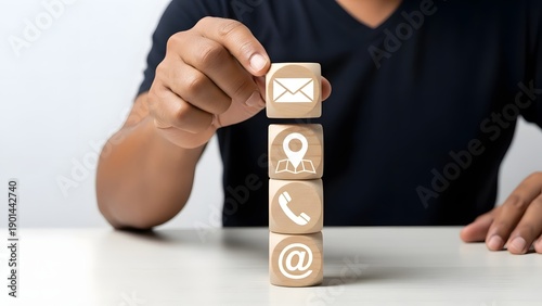 Person stacking wooden blocks with communication icons that represent different contact methods