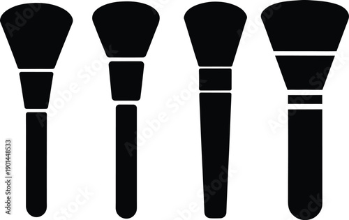 Four black makeup brushes in a row on white background