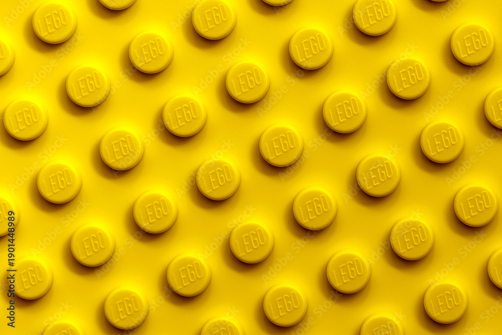 Fototapeta premium Vibrant Yellow LEGO Brick Surface Texture Background