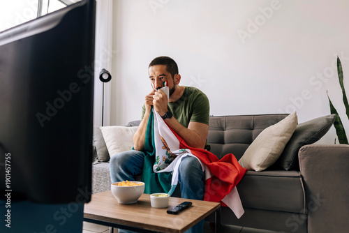 Tablou pe pânză Nervous Mexican soccer fan watching a football match at home