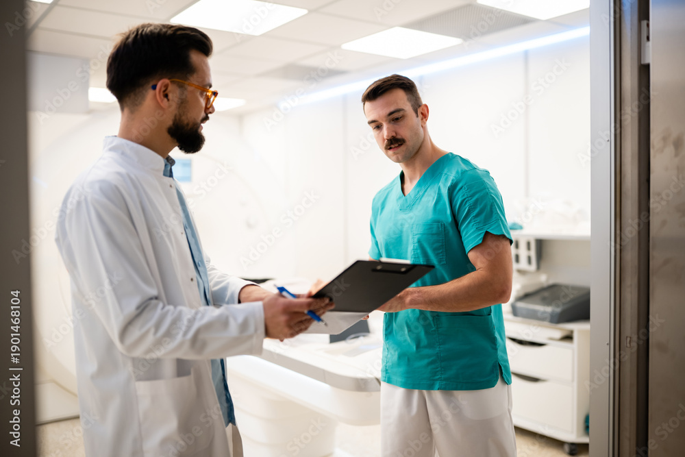 Obraz premium Doctors discussing treatment options in hospital ct scan room