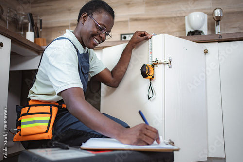 Wallpaper Mural Female Carpenter Taking Measurements of Kitchen Cabinets and Writing Notes Torontodigital.ca