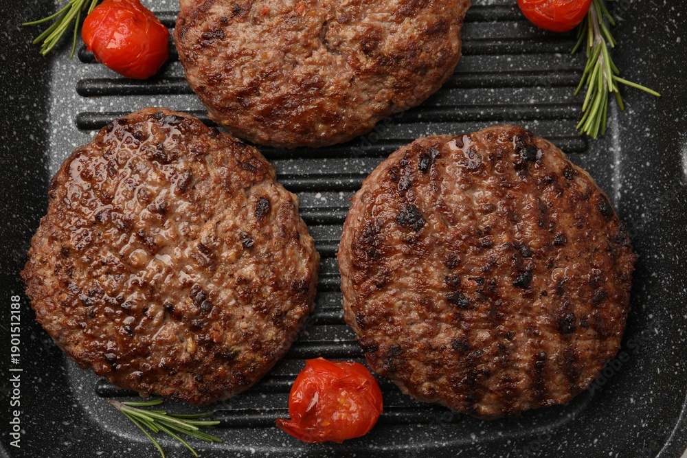 Fototapeta premium Delicious grilled meat patties, tomatoes and rosemary in grill pan, flat lay