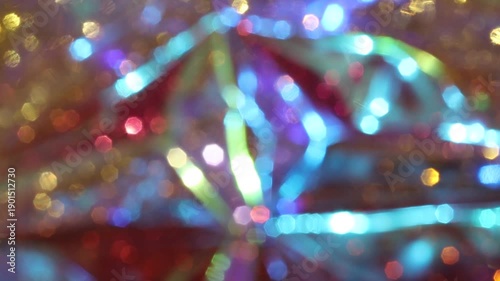 Shimmering bokeh rays create a vibrant and abstract festive backdrop.
