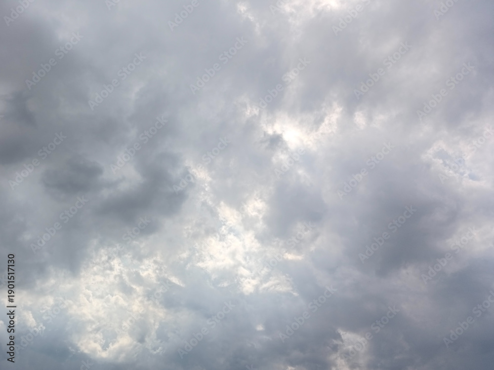 Obraz premium Dramatic Overcast Sky with Dark Stormy Clouds and Soft Sunlight Peeking Through, Moody Gray Atmosphere Background for Nature and Weather Concepts