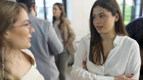 Young colleagues chatting and relaxing together during a casual work break in a modern office.