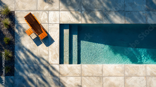 Modern stamped concrete patio with a pool and lounge chair