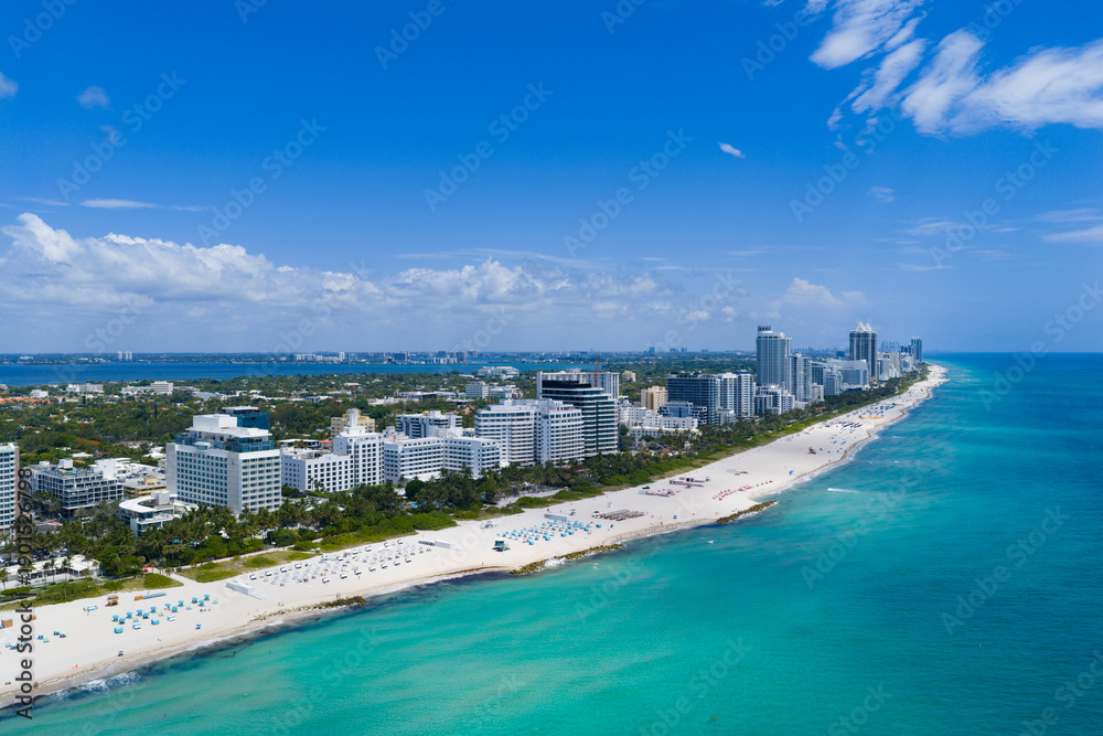 Fototapeta premium Drone aerial view of Miamis sandy beach. Miami coastline. Wide drone shot of Miami Beach and ocean waves. Miami beachscape captured from above. Oceanfront Miami resorts by drone.