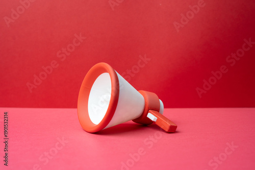 Фотография A megaphone lies on a red background