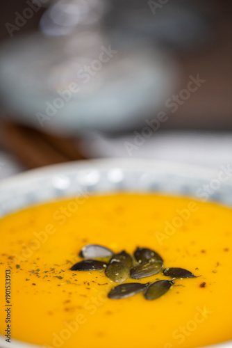 Kürbissuppe in einer Suppenschale auf einem gedeckten Tisch. Nahaufnahmeder Suppe.
