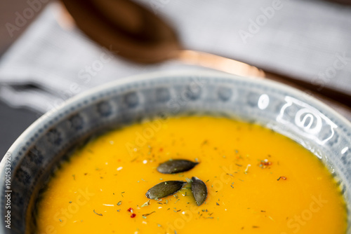 Kürbissuppe in einer Suppenschale auf einem gedeckten Tisch. Nahaufnahmeder Suppe.